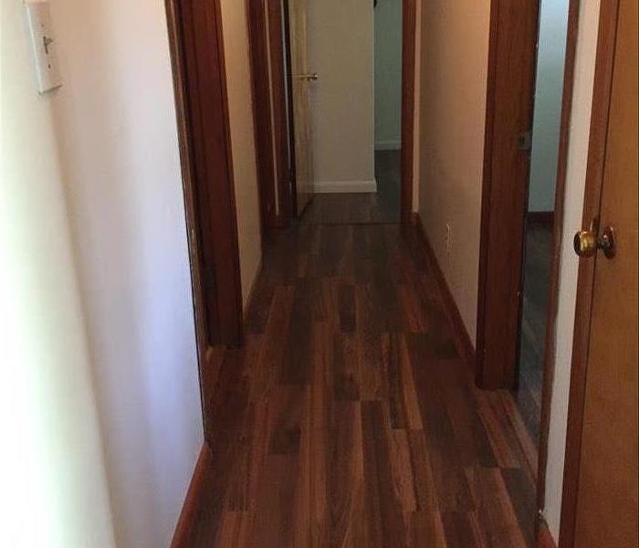 A hallway with brand new hardwood floors and new drywall
