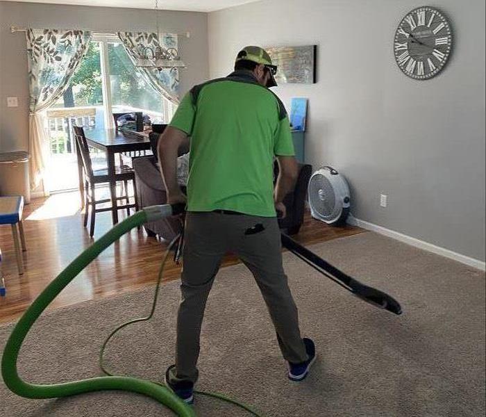 A man cleaning a living room carpet 